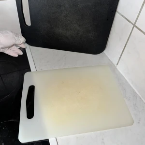 Skärbrädor skärbräda  - Bilderna visar två skärbrädor, en svart och en vit, båda med handtag. 👌🏻