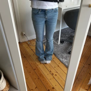 Bootcut jeans med slitna knän - Bootcut jeans i ljusblå denim med låg midja och slitna detaljer vid knäna. Säljer då dom inte kommer till användning men dom är både sköna och snygga!!