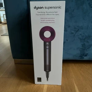 Dyson Supersonic hårfön  - Dyson Supersonic hårfön med snabb torkning och ingen extrem värme. Passar alla hårtyper och levereras med fem magnetiska stylingtillbehör. Skyddar hårets naturliga glans och minskar friss. Produkten är ny i förpackning, utan synligt slitage eller defekter.
