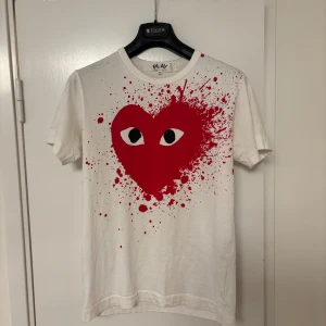 Vit t-shirt Comme des Garçon M - Säljer en vit t-shirt från Comme des Garçons Play i storlek M. Knappt använd med ett snyggt tryck på framsidan. 100% bomull. Made in Japan. Hör av dig vid frågor!