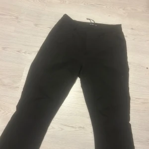 Svarta kostymbyxor från Bik Bok - Svarta kostymbyxor från Bik Bok som är utsvängda. snvända några gånger, annars i bra skick!! Skriv vid funderingar ellrr om mer bilder krävs❤️