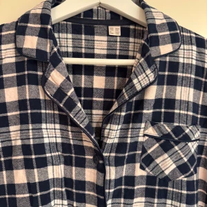 Skjortklänning i flanell  - Rutig skjortklänning i flanell med klassisk krage, knäppning framtill och en bröstficka. Långärmad och tillverkad i superskön mjuk bomull.