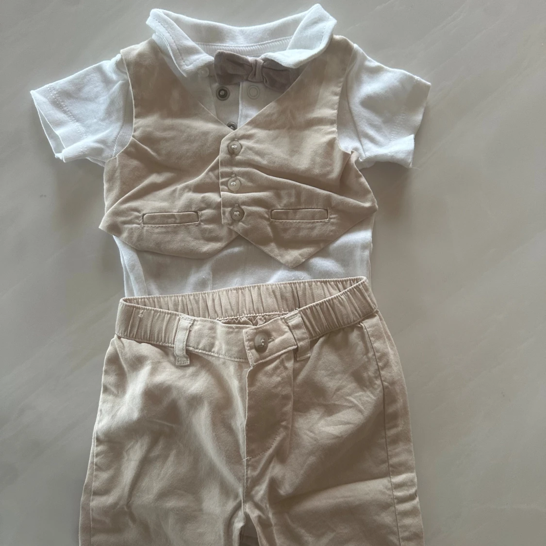 Beige och vit babykostym med fluga