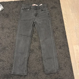 Levi's 551Z grå jeans straight fit - Säljer ett par Levi's 551Z Authentic Straight jeans i mörkgrå tvätt. Klassisk femficksmodell med raka ben och normal passform. Jeansen har en snygg vintage-look och är tillverkade i slitstarkt denim. Perfekta för dig som gillar tidlös stil.
