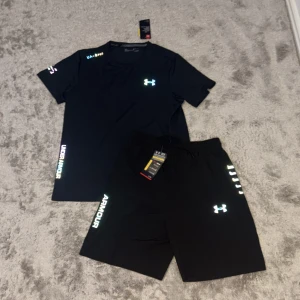 Svart Under Armour Set Reflective - Reflective Under armour Set. Size på shortsen M och på tröjan L, men inte stor skillnad på storlekarna