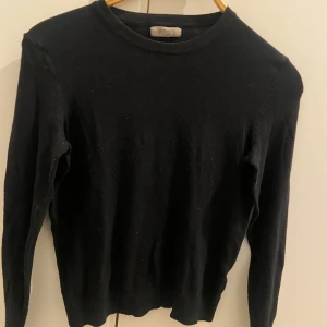 Svart stickad tröja med rund hals - En enkel svart stickad tröja med rund hals och långa ärmar. Perfekt för dig som gillar stilrena och klassiska plagg. Mjuk och skön känsla, passar till jeans eller kjol. Snygg att bära lager på lager under höst och vinter.