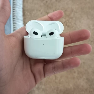 AirPods 3 - Snygga Apple AirPods 3 med laddningsetui. Trådlösa hörlurar med bra ljud och smidig anslutning till iPhone. Skick: Helt nya, mindre ytliga repor på etuiet men inga synliga defekter på hörlurarna. Perfekt för musik, samtal och träning.