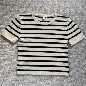 Randig topp -  Beige randig topp från Gina i storlek 158/164. Säljer denna på grund av att den va i fel storlek och sedan glömt skicka tillbaka. Den har aldrig använts. 