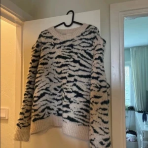 Zebramönstrad stickad tröja - Väldigt skön stickad tröja i zebra mönster med färgerna mörkrön och vit. Tröjan har markerade axlar🩷 bra skick!