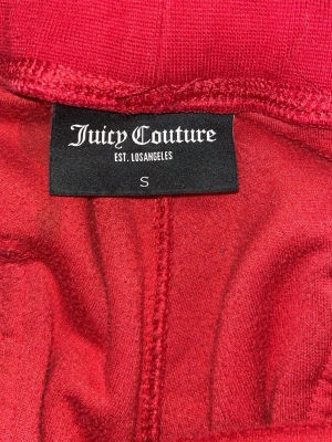 Röda mjukisbyxor Juicy Couture S - Säljer ett par klassiska röda mjukisbyxor från Juicy Couture i storlek S. Byxorna har bred resår i midjan , stora fickor fram och bak samt är gjorda i mjuk sammet. Perfekta för en chill och trendig look.