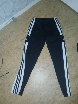 Adidas byxor - Ett par adidas byxor i storlek M. Jag har använt dem en gång och bara legat i min kläd låda så skulle säga att de e precis på nytt inget slitet alls. Äkta adidas med tre ränder