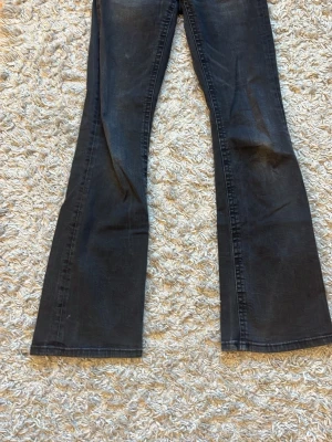 Jättesnygga jeans ifrån Gina!! - Snygga svarta bootcut jeans från Gina Tricot i storlek 164. Jeansen har klassisk femficksdesign med detaljerade ficklock bak och silverfärgade knappar. Materialet är slitstarkt jeans med en tvättad look och markerade sömmar😇🙏🏼