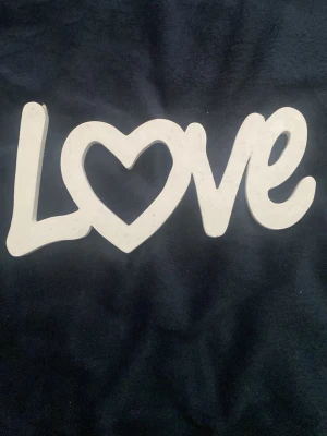 Love tavla  - Det här är en sak man hänger upp på vägen där det står Love på. Det är en perfekt sak för dig som tycker om vit och kärlek.