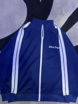 Palm Angels Half-Zip Hoodie – Premium Streetwear, Unisex - Upptäck den ikoniska stilen från Palm Angels med denna half-zip hoodie. Tillverkad i mjuk, högkvalitativ bomull för maximal komfort och hållbarhet. Den minimalistiska designen med subtil logotyp gör den perfekt för både vardag och streetwear. Detaljer: