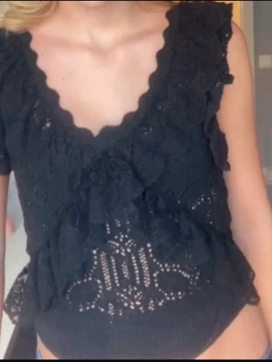 Svart blus med volanger och spets - Supersöt svart blus med volanger. Dem är från zara i storlek S! skriv om fler bilder eller du undrar något💓