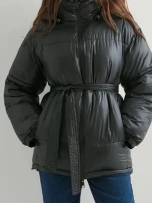 Svart pufferjacka med bälte - Säljer en svart pufferjacka med bälte i midjan och hög krage. Jackan har en glansig finish, långa ärmar och praktiska fickor. Perfekt för kalla dagar när du vill hålla dig varm och ändå se snygg ut. 🔥Jackan är slutsåld på hemsidan och kostar 800kr🔥.