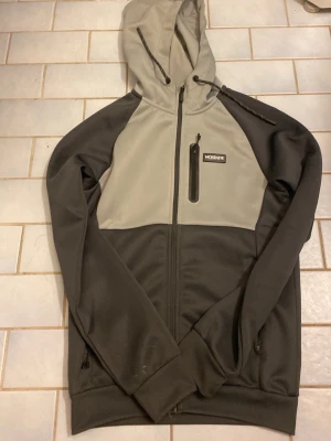 En mckenzie hoodie  - Jag säljer en mckenzie hoodie med färgerna grå och svart den har en luva mckenzie märket på vänstra sidan av hoodien ochden har storlek S den har också två fickor 