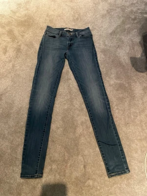 Levi's 511 skinny jeans blå - Säljer ett par klassiska Levi's 511 skinny jeans i blå tvätt. Jeansen har fem fickor, smal passform och normal midja. Tillverkade i stretchigt denim för extra komfort. Perfekta för dig som gillar en tajtare look och vill ha ett par stilrena jeans.