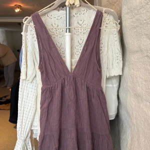 Lila kortklänning i linne - Supersöt lila kortklänning med djup v-ringning och breda axelband