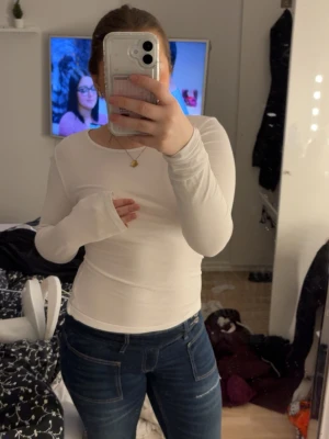 Vit långärmad topp från H&M - En basic vit långärmad topp från H&M i storlek S. Toppen har rund halsringning och är figurnära med stretchigt material, perfekt att styla med jeans eller kjol. Enkel och stilren design som funkar till många olika looks.