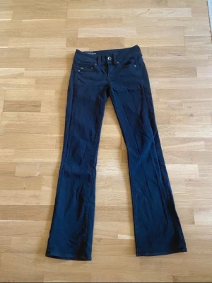 G-Star Raw Midge Bootcut Jeans Svarta - Säljer ett par svarta G-Star Raw Midge Saddle Mid Skinny Bootcut jeans. De har klassisk femficksdesign, snygga detaljer med dubbla knappar bak och är tillverkade i stretchig bomullsmix för skön passform. Bootcut-ben och midwaist gör dem riktigt stilrena.