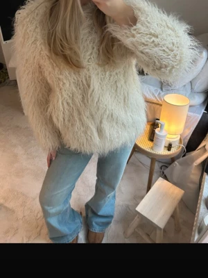 Beige fluffig pälsjacka från H&M - Säljer en supermysig och fluffig beige pälsjacka från H&M. Jackan har långärmade ärmar och en loose passform som ger en cool och avslappnad vibe. Perfekt för dig som vill sticka ut med en statement piece i garderoben. De två första bilderna är från tjejen jag köpte den från då den först är köpt på Vinted. Men jag har aldrig använt den, utan endast testad, och den ser knappt använd ut! 