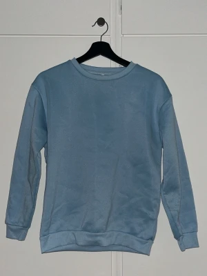 Ljusblå sweatshirt i bomull - En enkel och stilren ljusblå sweatshirt. Är inte nopprig. Använd ett par gånger och är från SHEIN. 