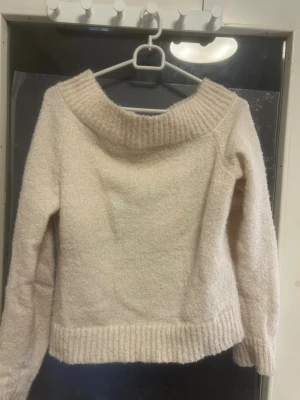 Beige stickad offshoulder tröja - Mysig beige stickad tröja med bred offshoulder-krage och ribbade detaljer vid hals, nederkant och ärmslut. Aldrig använd fick i present, däremot vet jag inte var den e ifrån. (Pris kan alltid diskuteras)🩷