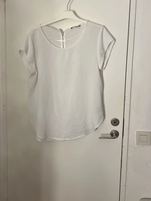 Vit blus från ONLY med dragkedja - Säljer en enkel och stilren vit blus från ONLY i storlek L. Blusen har korta ärmar, rund halsringning och en snygg dragkedja bak i nacken. Tillverkad i ett lätt och mjukt material som känns skönt mot huden. Perfekt till jeans eller kjol. Pris kan diskuteras, tvätt ingår innan leverans ❤️