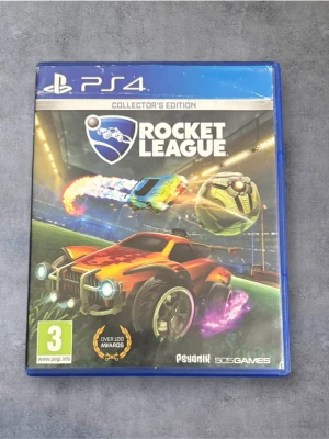 Rocket League Collector's Edition PS4 - Rocket League Collector's Edition till PS4, komplett med fodral och skiva i fint skick. Ett populärt bilfotbollsspel med flerspelarläge, över 100 utmärkelser och extra DLC-innehåll. Perfekt för både solo- och multiplayerupplevelser. Inga synliga defekter eller slitage.