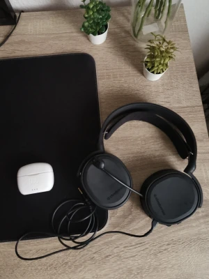 JBL trådlösa Bluetooth hörlurar & SteelSeries headset för ps4-5 - Säljer ett par vita JBL trådlösa hörlurar med laddningsetui, samt ett SteelSeries kabelanslutet spelheadset med mikrofon. Båda produkter är i gott skick utan synligt slitage. Perfekt för musik, samtal och gaming. Komplett paket för både mobil och dator. Finns en liten spricka på jbl skalet