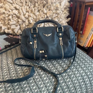 Zadig&Voltaire sunnybag - En liten sunny bag i den finaste blå/gröna färgen. Cool med nitar, som tyvärr sitter lite löst men ingen som man tänker på när den bärs. Även en pytteliten rosa fläck på lädret (bild 5). Däremot finns inget slitage på kedjorna utan de har kvar sin silver färg! 