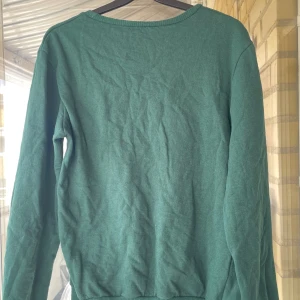 Grön basic långärmad tröja - Enkel grön långärmad tröja med rund halsringning och ribbade muddar. 