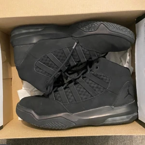 Jordan Max Aura svarta sneakers - Säljer ett par svarta Jordan Max Aura sneakers i storlek 39. Skorna har en hög modell med snörning, meshpaneler och detaljer i syntet och skinn. Snygg, sportig look med diskret Jumpman-logga på sidan och slitstark sula.