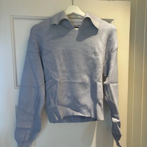 Ljusblå stickad tröja från Gina Tricot - Superfin ljusblå stickad tröja från Gina Tricot med krage och lång ärm. Tröjan har en relaxed fit och bred ribbad mudd nertill och vid ärmslut. Perfekt att styla med jeans eller kjol för en chill look.