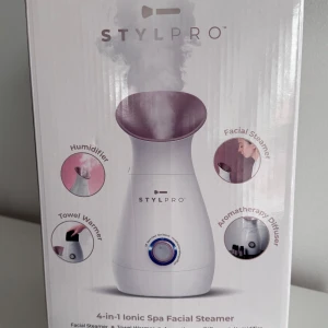 STYLPRO 4-in-1 Ionic Spa Facial Steamer - STYLPRO 4-in-1 Ionic Spa Facial Steamer erbjuder ansiktsångare, handduksvärmare, aromaterapidiffusor och luftfuktare. Förbättrar hudens cirkulation, öppnar porer och är lätt att använda. Levereras med mätkopp, manual och EU/UK-kontakt. Produkten är ny i förpackning.