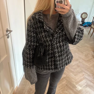 Trekvartsärmad höstjacka - Sååå fin svartvit klassisk hundtandsmönstrad jacka. Jackan har bred krage, trekvartsärmar och i ullblend. Perfekt för dig som gillar en trendig och klassisk look. I fint skick , perfekt till hösten !! 🩷