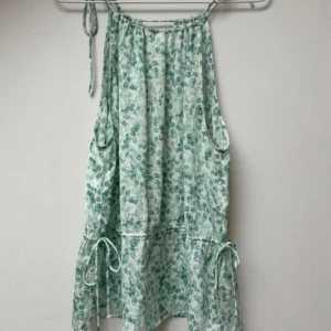 Blus från H&M - ALLA PLAGG SKICKAS SAMMA DAG SOM BESTÄLLNING Jättefin blus/halterneck topp med knytning runt midjan och vid axlarna samt öppna sidor från H&M. Den är köpt för flera år sedan men aldrig använd. Den är mönstrad i ljus-och-mörk grön. Passar storlek XXS-L 