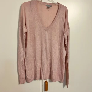 Ljusrosa v-ringad tröja från H&M - Supersöt ljusrosa tröja från H&M med v-ringning och långa ärmar. Tröjan är tunn och mjuk, perfekt för lager-på-lager. Ribbad kant vid halsringning, ärmslut och nederkant. Enkel och stilren design som funkar till allt.