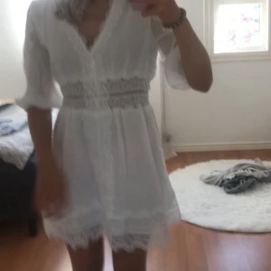 Vit spetsklänning från Zara - Superfin vit kortklänning från Zara med v-ringning och vackra spetsdetaljer längs ärmar, midja och nederkant. Klänningen har trekvartsärmar och är gjord i ett lätt material som känns luftigt och somrigt. Perfekt för student eller skolavslutning! Endast använd en gång så superfint skick , säljs inte längre