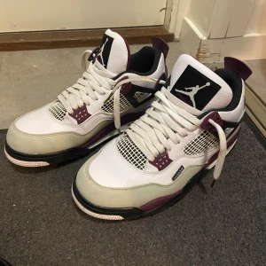 Jordan 4 PSG 43 - Säljer ett par snygga Jordan 4 Paris Saint-Germain sneakers i vitt och vinrött med svarta detaljer. Skriv för detaljbilder och funderingar! (Kommer med box!) (Rengör dem innan jag skickar!)