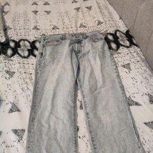 Ljusblå jeans från Woodbird - Säljer ett par ljusblå jeans från Woodbird med klassisk femficksdesign och raka ben. Jeansen har en snygg tvättad look och är tillverkade i bomull. Perfekta för dig som gillar en avslappnad och stilren vibe.