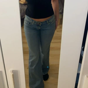 Lågmidjade bootcut jeans ljusblå - Säljer ett par lågmidjade ljusblå jeans med bootcut passform. Klassisk femficksmodell i mjukt denimtyg! Jeansen är helt nya och endast testade hemma. Jättefin modell på jeansen och väldigt långa i benen (är 1,72 cm lång) Ni är varmt välkomna att höra av er vid frågor eller mer info🥰 Storlek 26 (midjan) 34 (längden) Nypris: 949 Sel