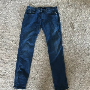 Replay Anbass Hyperflex jeans blå - Säljer ett par blå Replay Anbass Hyperflex jeans med klassisk femficksdesign och snygga sömmar på bakfickorna. Jeansen har normal passform och är tillverkade i stretchigt jeansmaterial för extra komfort. Perfekta för dig som gillar stilrena och bekväma jeans. Storlek 33/34, as bra skick på dom, nypris 1200 mitt pris 499. Priset kan diskuteras