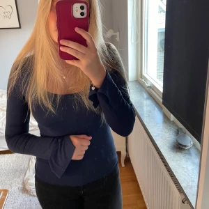 Mörkblå långärmad topp Gina Tricot - Säljer en mörkblå långärmad topp från Gina Tricot i storlek S. Toppen har en snygg, fyrkantig urringning och är figurnära med långa ärmar. Perfekt att styla med jeans eller kjol för en clean look.