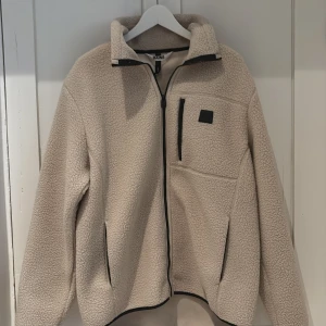 Beige fleece jacka från Rains - Säljer nu en helt oanvänd fleece jacka från Rains. Perfekt för hösten. Nypris 1999kr men säljs för 1500 pris kan diskuteras!
