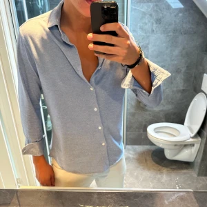 Ljusblå skjorta Massimo dutti - Snygg ljusblå skjorta med klassisk krage och vita knappar från Massimo dutti. Skjortan har lång ärm och en avslappnad passform. Jag är 188cm och bär storlek M. Skjortan har inga defekter och är i bra skick. Hör av er vid frågor;) 