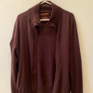  kofta från Devred - Snygg mörkröd kofta från Devred i storlek XL Koftan har knappar framtill, ribbade muddar och en klassisk krage. Perfekt att slänga över en skjorta för en clean look. Materialet känns mjukt och är troligtvis ullblandning. Storleken är xl, men passar snarare Medium/large