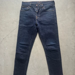 Mörkblå jeans från Nudie Jeans - Säljer snygga mörkblå jeans från Nudie. Jeansen är stora i storleken och passar 170 och uppåt. Jeansen har en slim fit passform som ger en stilren look. Skriv vid minsta lilla fråga😀