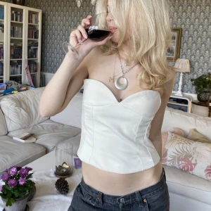 vit korsett topp - Säljer en vit korsett topp med snygg hjärt ringning och dragkedja i ryggen. Toppen är axelbandslös. Alla bilderna är mina🤍